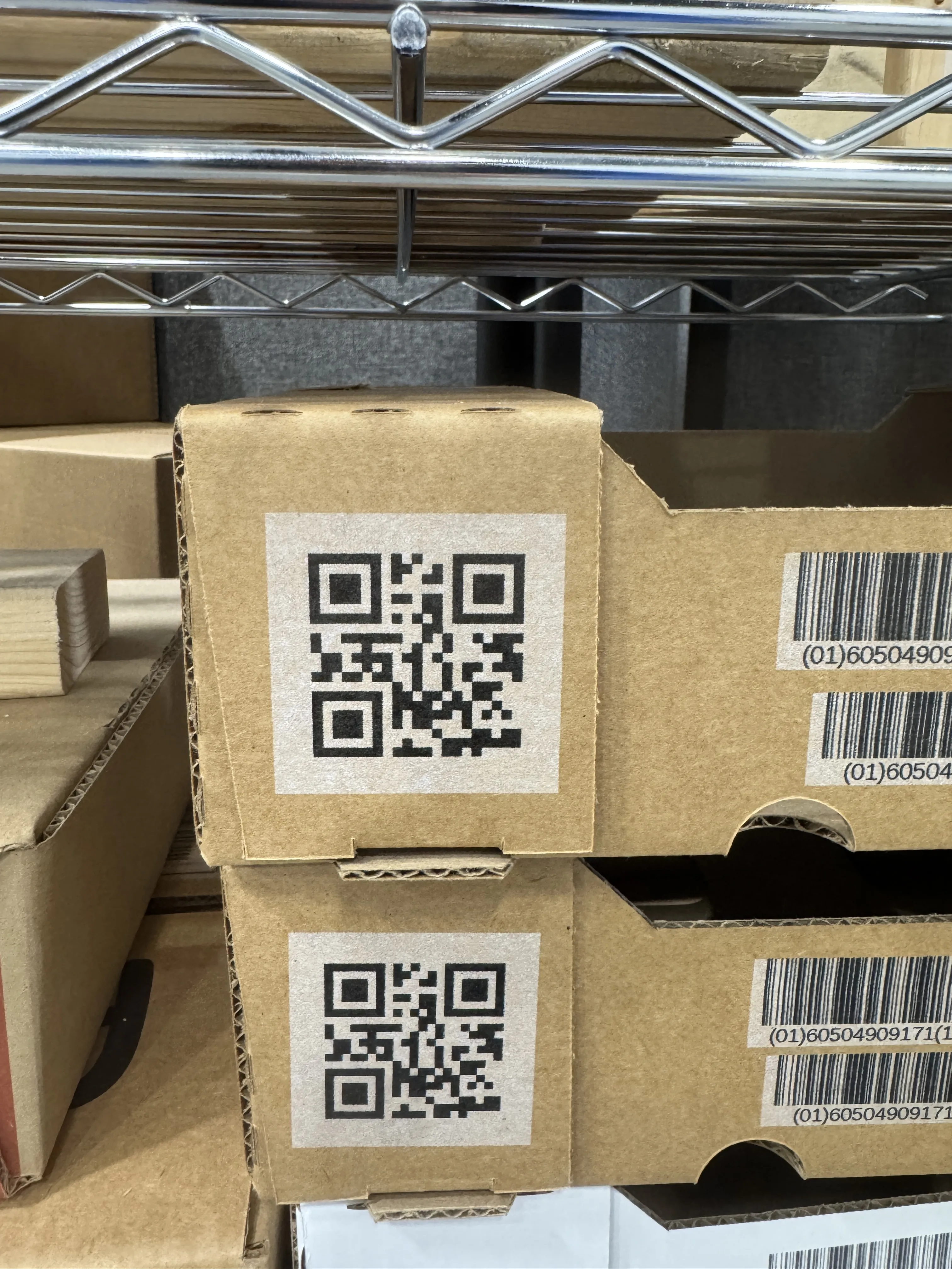 Bruna kartonger med stora QR-koder och streckkoder på en hylla
