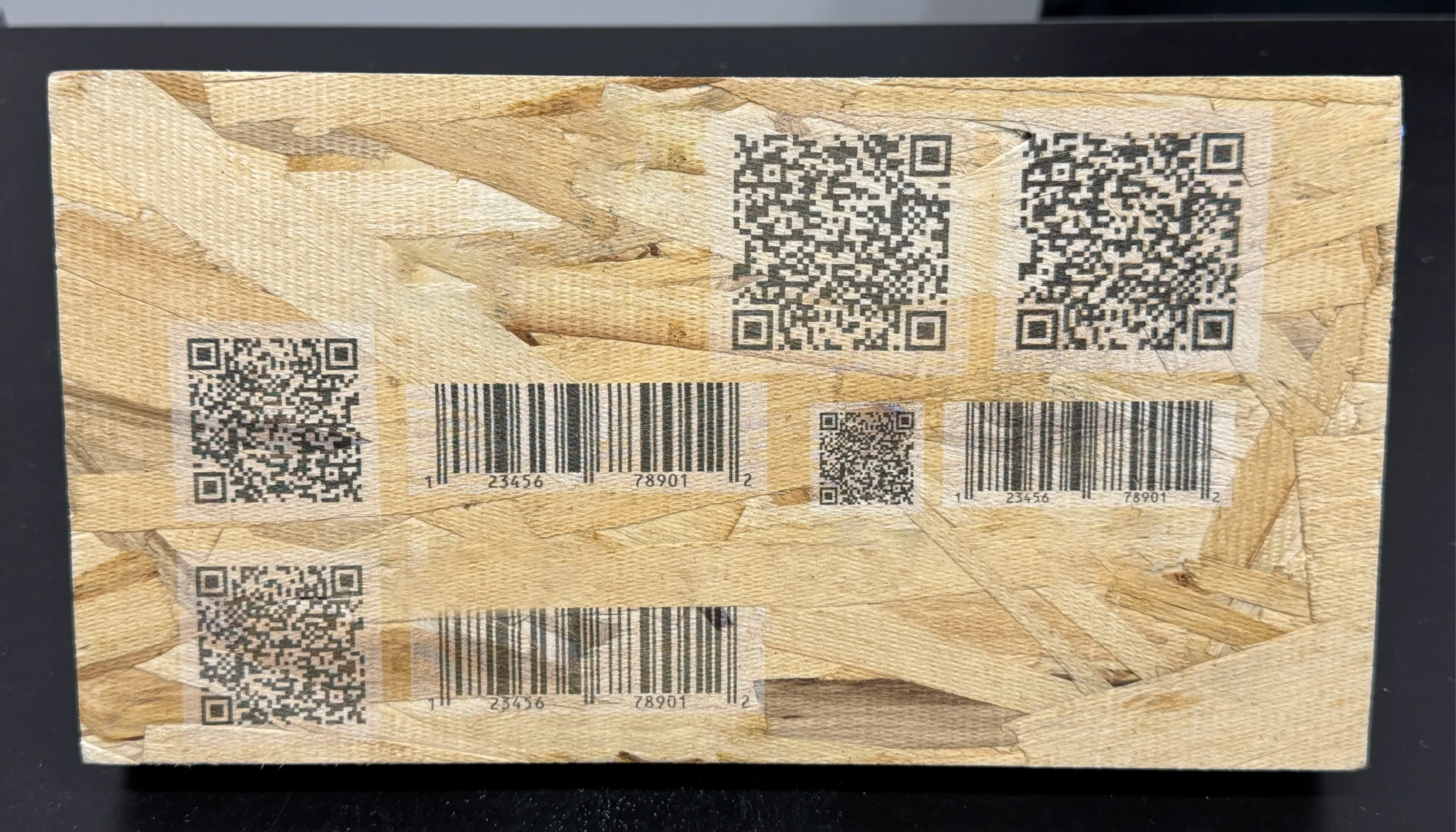 OSB-skiva med QR-koder och streckkoder tryckta direkt på skivan