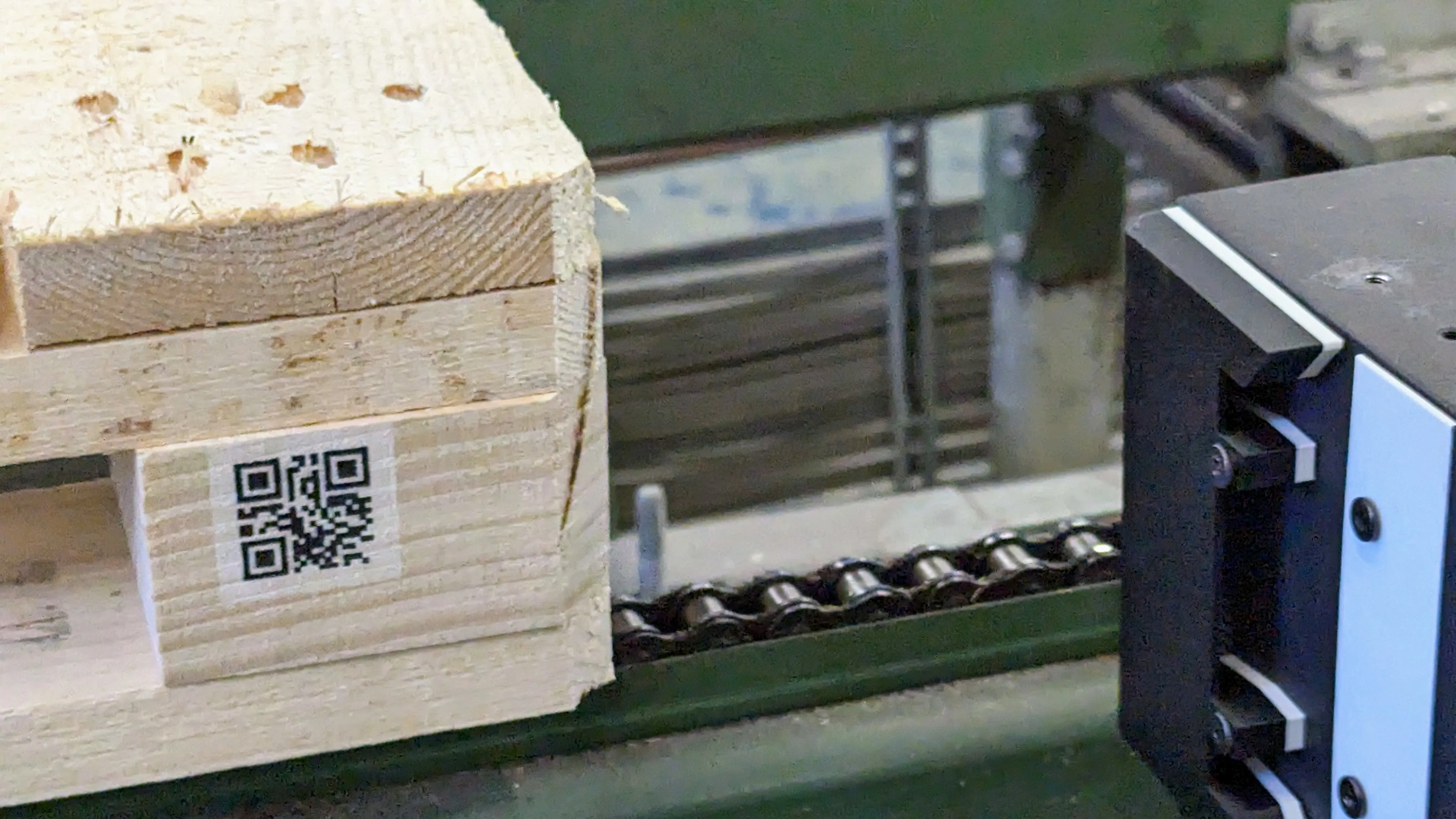 Pall på transportör med svart QR-kod på vit bakgrund på en träkloss
