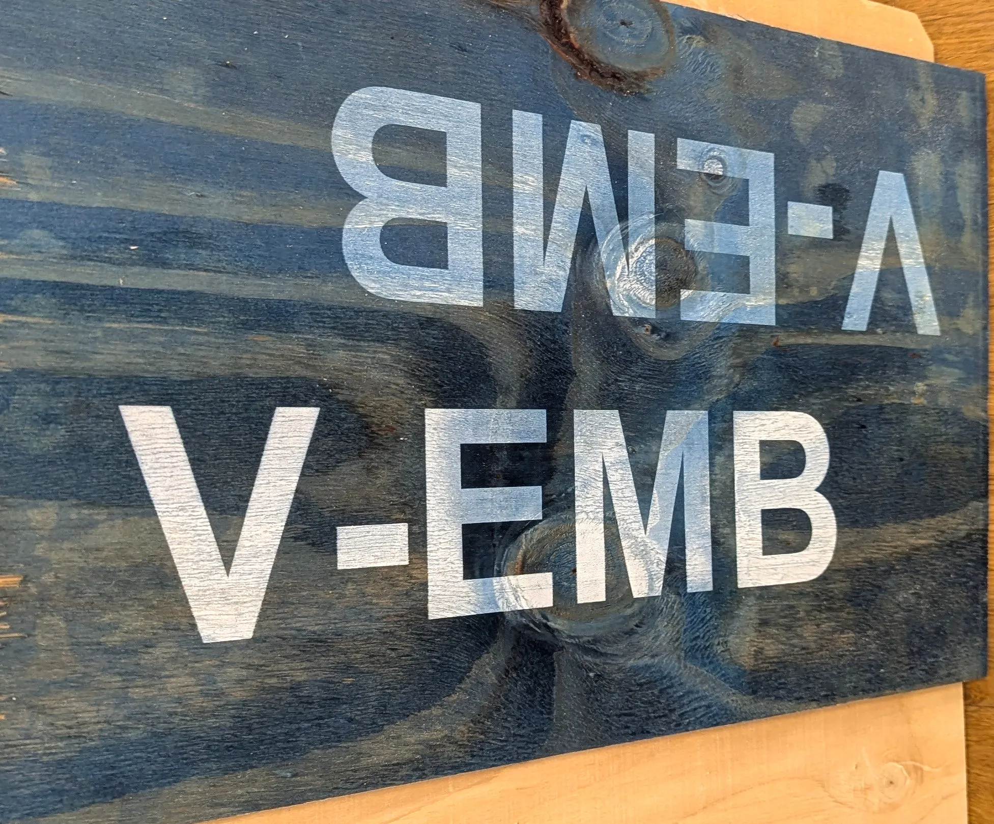 Blåmålad plywood med vit text tryckt på torr och våt skiva